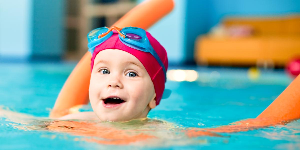 Young boy learning to swim in pool