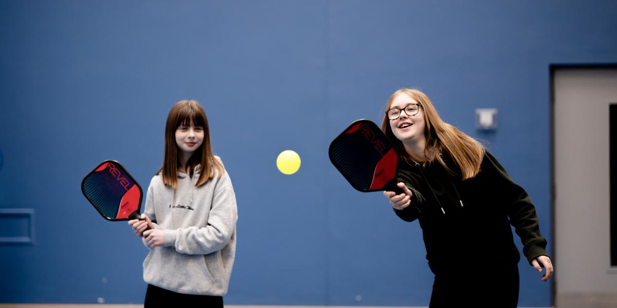 2 girls playing pickleball